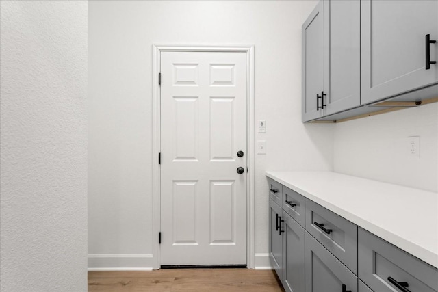 laundry area with light wood-type flooring