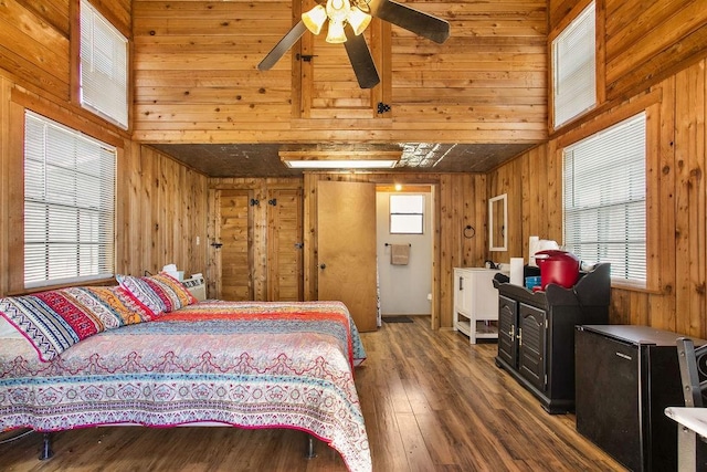 bedroom with wood walls, ceiling fan, and hardwood / wood-style flooring