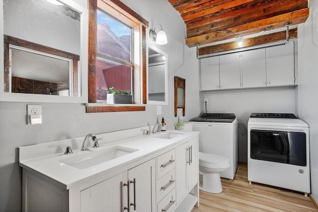 bathroom with hardwood / wood-style flooring, washer and dryer, toilet, and vanity