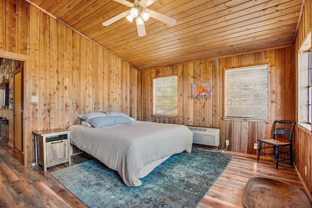 bedroom with ceiling fan, wooden ceiling, a wall mounted air conditioner, wood-type flooring, and wooden walls