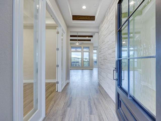 hallway with beam ceiling and light hardwood / wood-style flooring