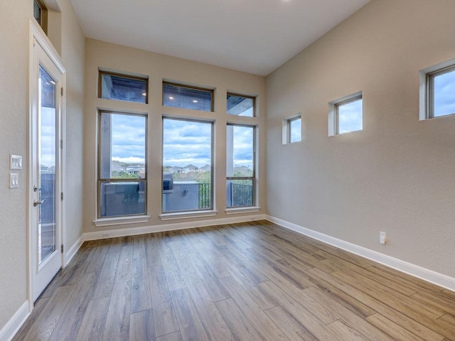 unfurnished room featuring light hardwood / wood-style floors and plenty of natural light