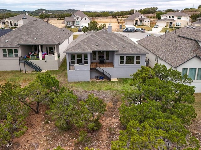 19516 Tranquility Falls Path, Lago Vista, TX 78645 - back of house featuring stairway, a residential view, a shingled roof, and stucco siding