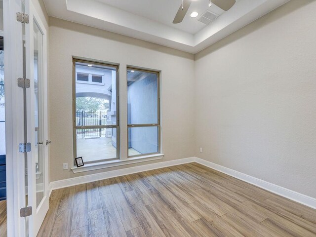 19516 Tranquility Falls Path, Lago Vista, TX 78645 - empty room featuring wood finished floors, ceiling fan, french doors, and a raised ceiling