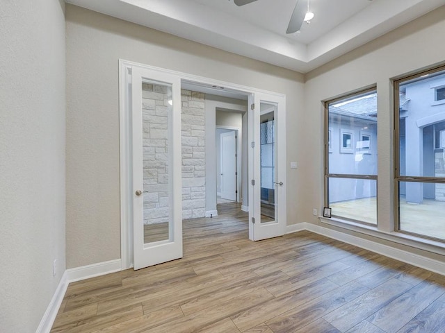 spare room featuring ceiling fan, french doors, and light wood-type flooring