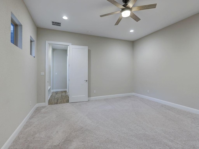 empty room with ceiling fan and light colored carpet