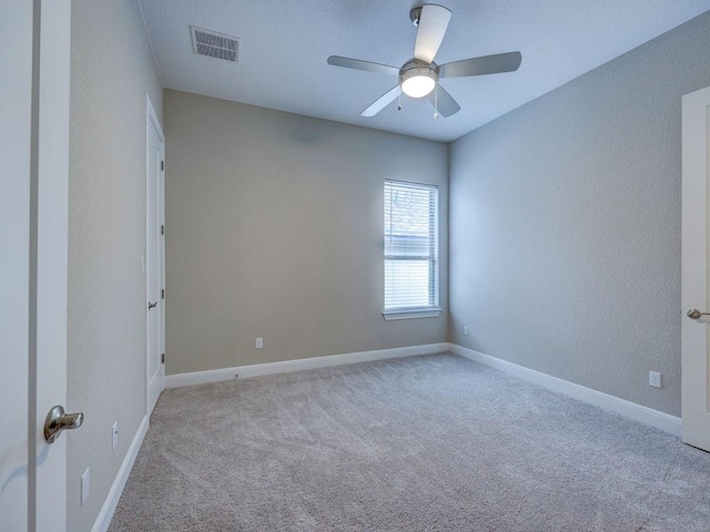 carpeted spare room with ceiling fan