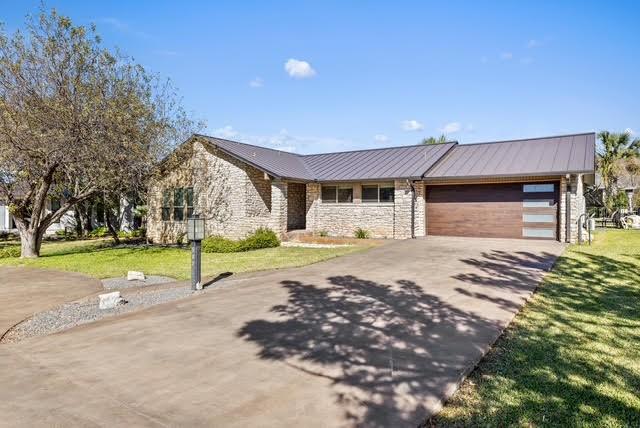 single story home with a front yard and a garage