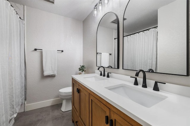 bathroom featuring vanity, toilet, and a textured ceiling