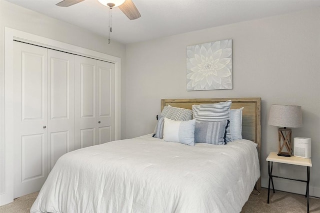 bedroom featuring light colored carpet, a closet, and ceiling fan