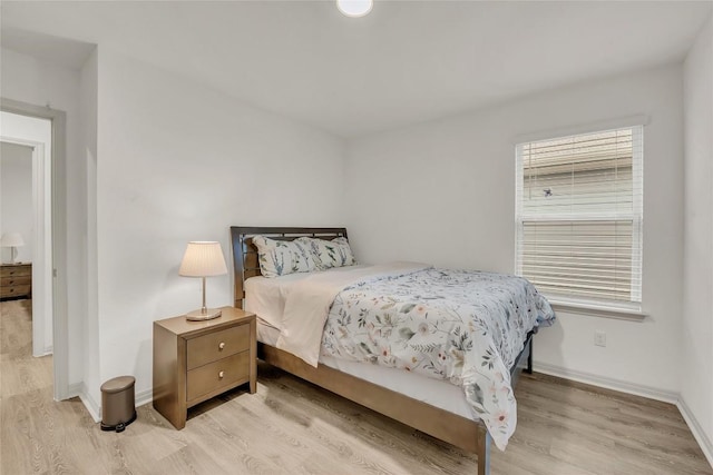 bedroom with light hardwood / wood-style flooring and multiple windows