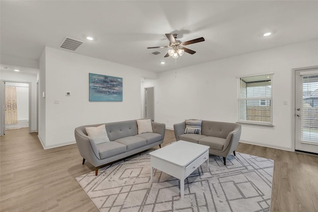 living room featuring ceiling fan and light hardwood / wood-style floors