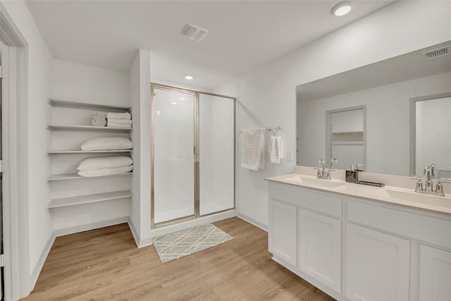 bathroom featuring vanity, wood-type flooring, and a shower with door