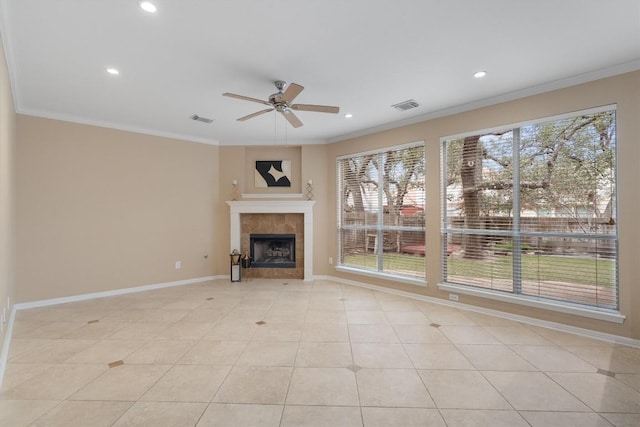 unfurnished living room with ceiling fan, light tile patterned flooring, crown molding, and a tile fireplace