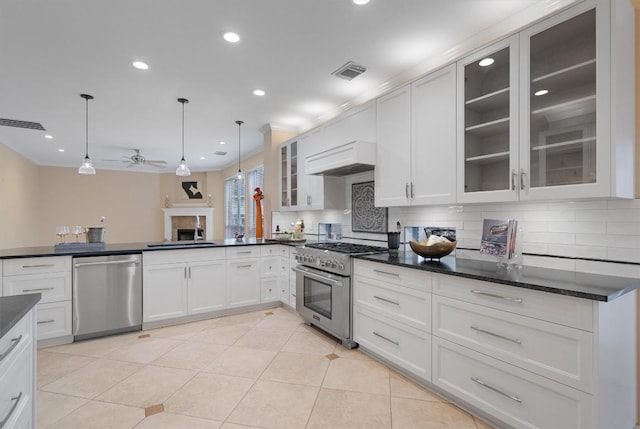 kitchen with custom range hood, stainless steel appliances, ceiling fan, decorative light fixtures, and light tile patterned flooring