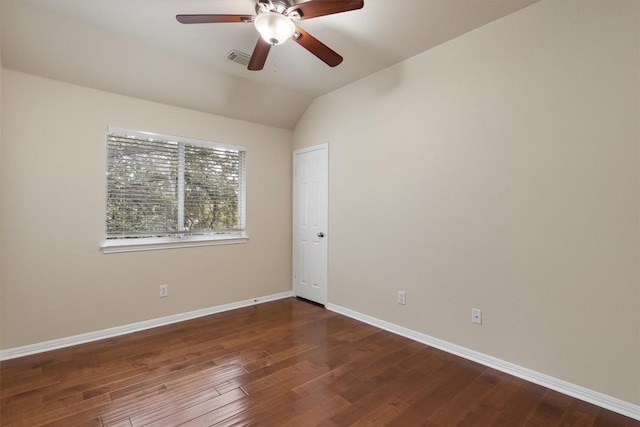 spare room with dark hardwood / wood-style flooring, vaulted ceiling, and ceiling fan