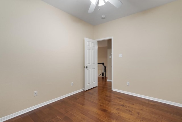 unfurnished room with ceiling fan and dark wood-type flooring