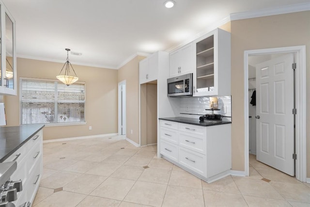 kitchen with crown molding, light tile patterned floors, white cabinets, and decorative light fixtures