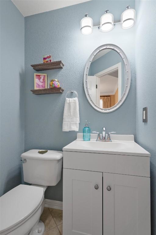 bathroom featuring tile patterned floors, vanity, and toilet