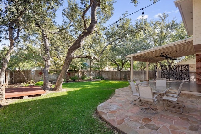 view of yard featuring ceiling fan and a patio area