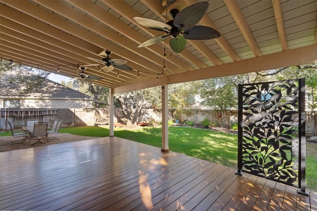 wooden terrace with ceiling fan and a yard