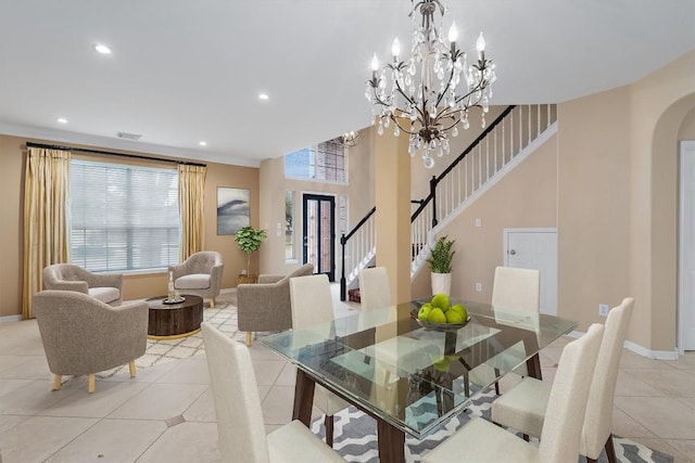 tiled dining space featuring a chandelier and ornamental molding