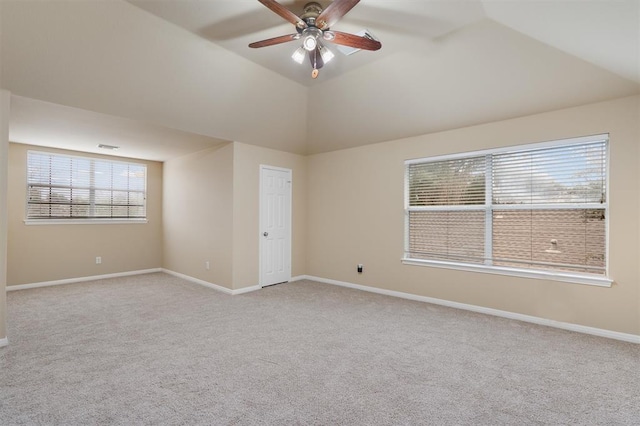 empty room featuring a wealth of natural light, ceiling fan, light carpet, and lofted ceiling