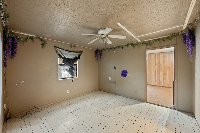 unfurnished room with ceiling fan and a textured ceiling