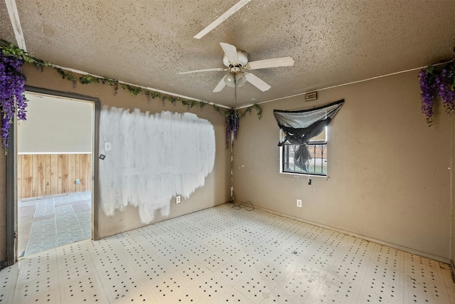 unfurnished room featuring ceiling fan and a textured ceiling