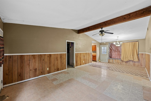 unfurnished living room with lofted ceiling with beams, wood walls, and ceiling fan with notable chandelier