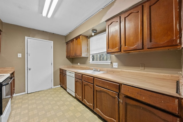 kitchen featuring white dishwasher, range with electric stovetop, and sink