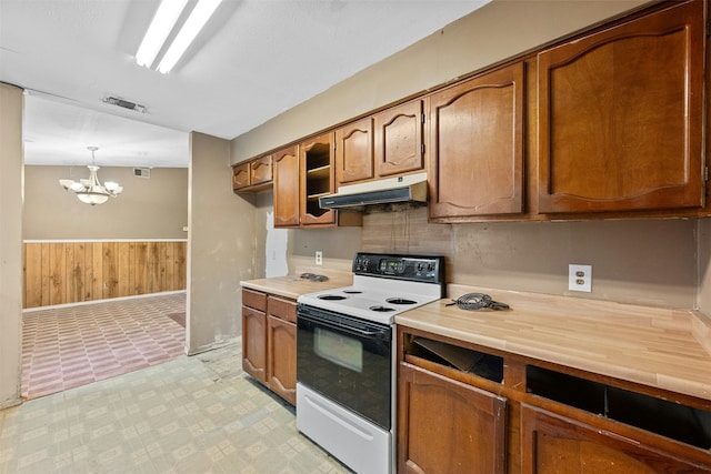 kitchen with white electric range oven, decorative light fixtures, an inviting chandelier, and wood walls