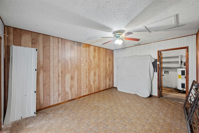 interior space featuring parquet floors, electric water heater, ceiling fan, and wooden walls