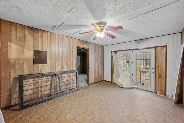 spare room featuring parquet flooring, electric panel, and wood walls