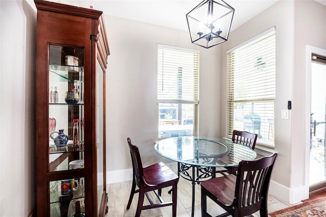 dining room with light wood-type flooring and a chandelier