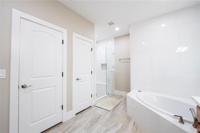 bathroom featuring vanity and tiled tub