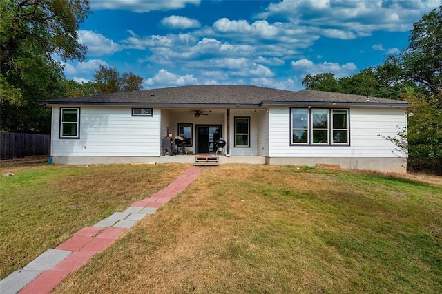 back of property featuring a lawn and ceiling fan