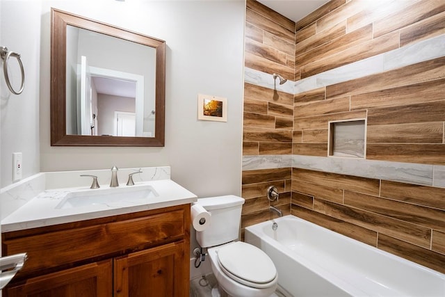 full bathroom featuring tiled shower / bath, vanity, and toilet