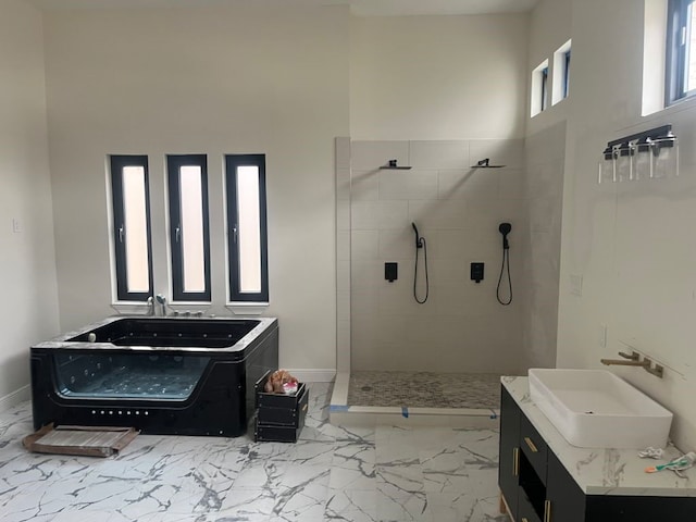 bathroom featuring a tile shower, vanity, and a high ceiling