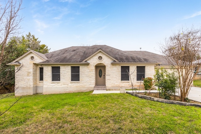 view of front facade with a front yard and roof with shingles