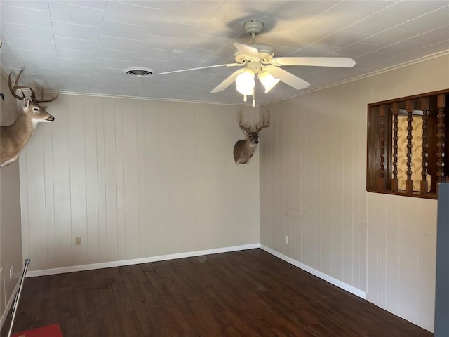 empty room featuring dark hardwood / wood-style flooring, ceiling fan, and crown molding