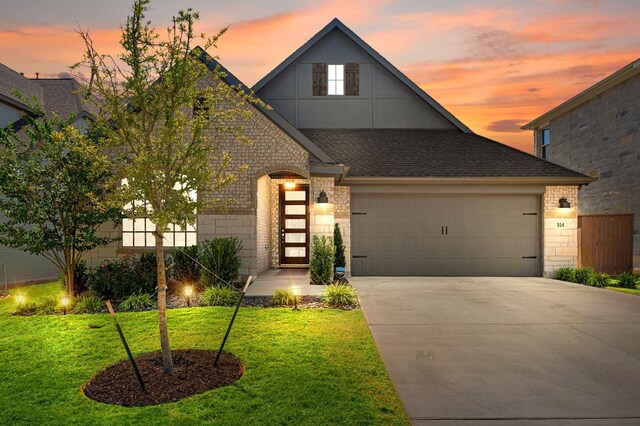 view of front of house with a garage and a lawn