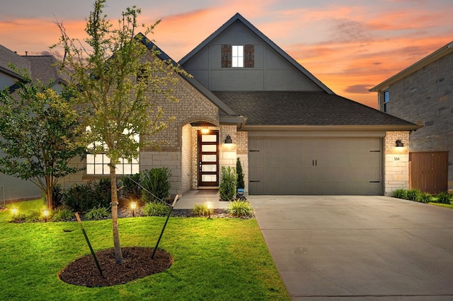 view of front of house featuring a garage and a yard