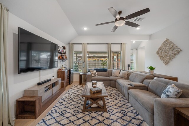 living room featuring ceiling fan, vaulted ceiling, and light wood-type flooring