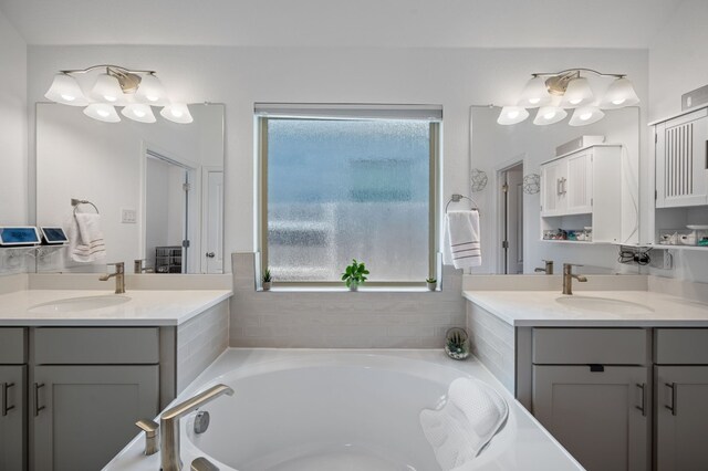 bathroom featuring vanity, plenty of natural light, and a bath