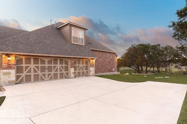 property exterior at dusk with a garage and a yard