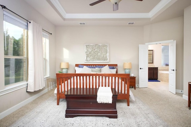 bedroom with ceiling fan, a raised ceiling, ornamental molding, and connected bathroom