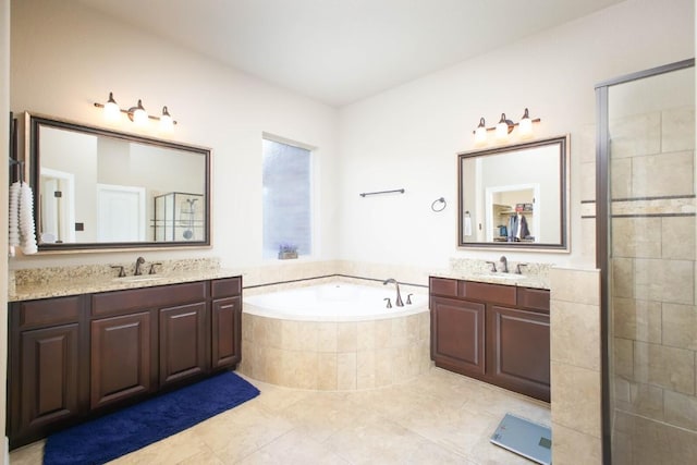 bathroom featuring shower with separate bathtub, vanity, and tile patterned floors