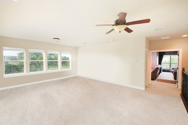 spare room with light colored carpet and ceiling fan