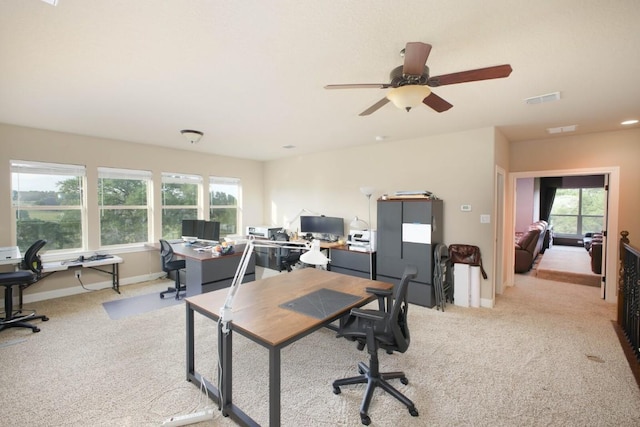 carpeted office space with ceiling fan